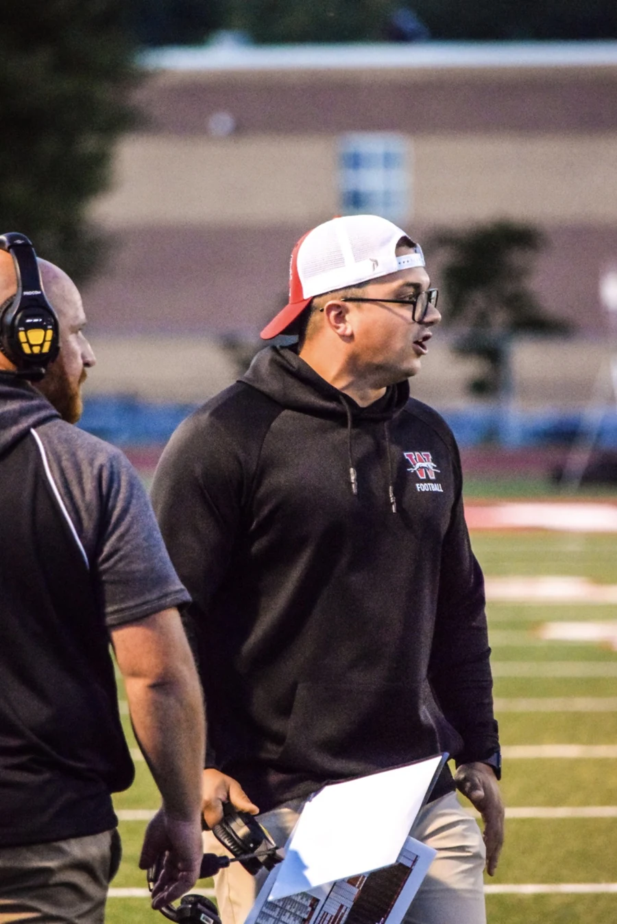 Coach Bartlett on the sideline holding a coaching sheet.
